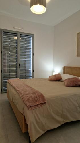 um quarto com uma cama grande com duas almofadas em Le Malakoff em Sérignan