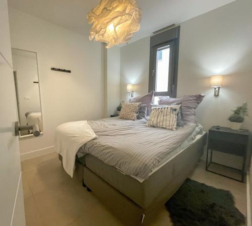 een slaapkamer met een groot bed met een kroonluchter bij Sunny Panorama in Torrox