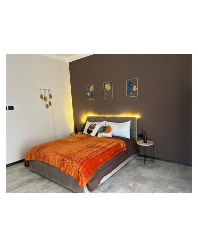 a bedroom with a large bed with a orange blanket at Pura Vida Apartment in Catania