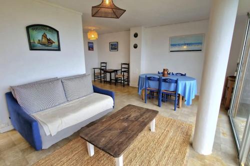 un salon avec un canapé et une table dans l'établissement Maison Le Panorama Tadou Coz 100% vue mer, à Ploubazlanec