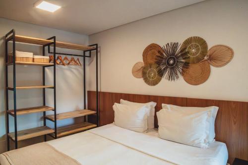 a bedroom with a bed with a fan on the wall at Pousada Moana in Fernando de Noronha