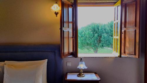 a lamp on a table in front of a window at Quinta do Burgo - Nature Hotel in Amares
