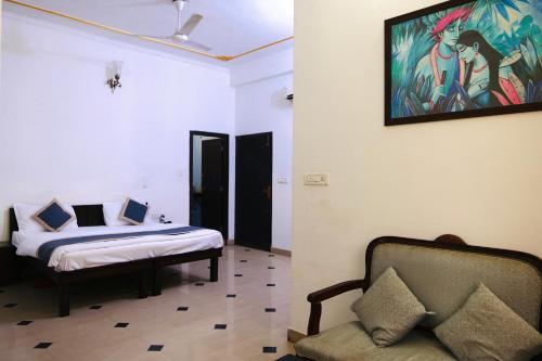 a bedroom with a bed and a couch and a painting on the wall at The Kunadi Heritage by Boho Stays in Jaipur