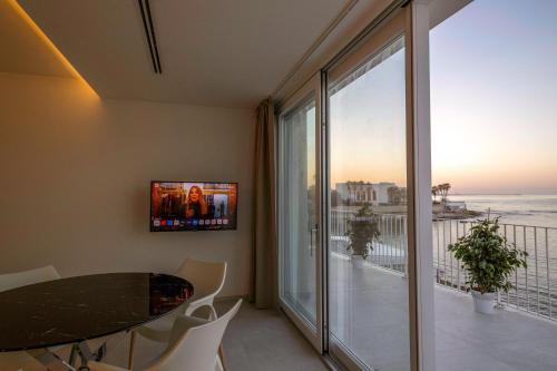 a dining room with a table and a view of the ocean at Calammare Apartments - Luxury Apartments with Beach and Gym - Molfetta in Molfetta