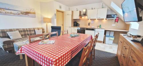 cocina y comedor con mesa y mantel rojo y blanco en FeWo Quint nahe Kap Arkona, en Altenkirchen