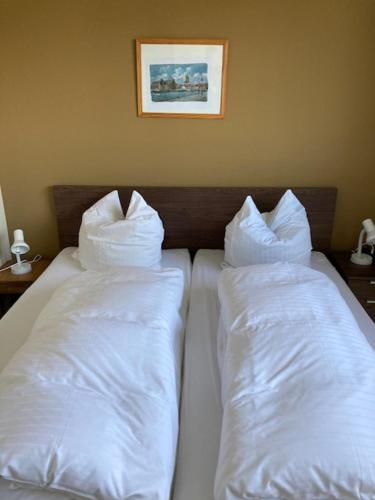 Duas almofadas brancas numa cama num quarto em Ferienwohnung Troge em Greifswald