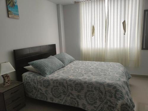 um quarto com uma cama e uma janela em Aparta-hotel medilaser-Uniboyaca em Tunja