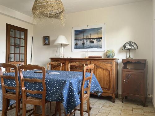 une salle à manger avec une table et un chiffon bleu dans l'établissement 356 - Maison vue mer pour 8 voyageurs, à Fréhel., à Fréhel