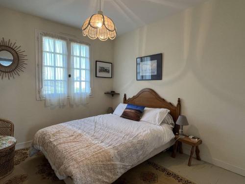 une chambre avec un lit et un lustre dans l'établissement 356 - Maison vue mer pour 8 voyageurs, à Fréhel., à Fréhel