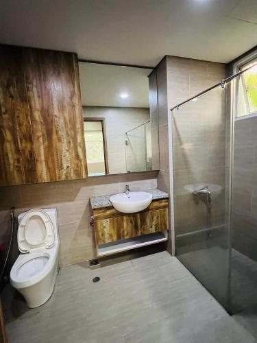 y baño con aseo, lavabo y ducha. en The Habitat en Thuan An