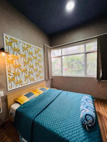 Un dormitorio con una gran cama azul y una ventana en The Habitat en Thuan An