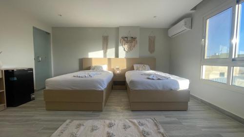 a bedroom with two beds and a window at Diyar Pyramids Inn in Cairo