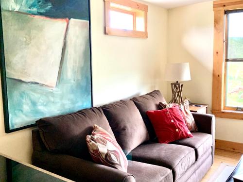 a living room with a brown couch with red pillows at Heartstone Country Retreat in Buena Vista
