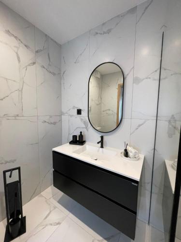 a bathroom with a sink and a mirror at OPORTO Suites in Moreira