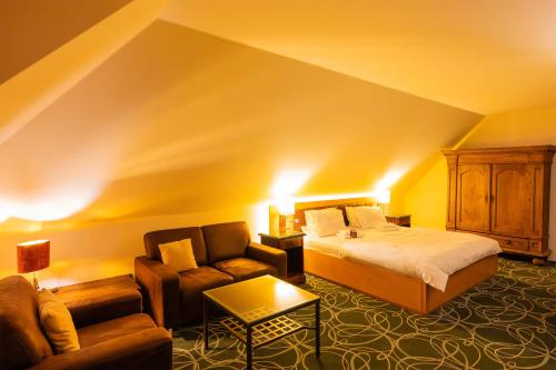 a hotel room with a bed and a couch at Zeitgeist Rathen by STEIGER Hotels in Kurort Rathen