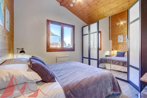 1 dormitorio con 2 camas y ventana en Les Césaries A4, en Morzine