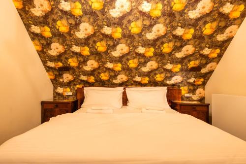 a bedroom with a bed with a floral wall at Zeitgeist Rathen by STEIGER Hotels in Kurort Rathen