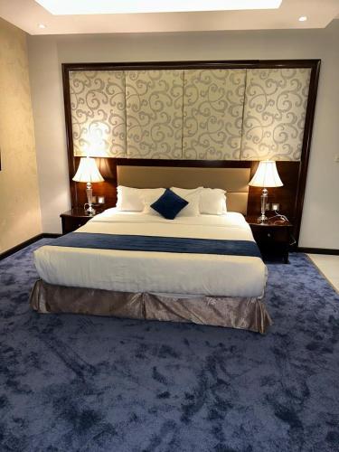 a large bed in a hotel room with two lamps at Maset Al Masem Apartments Units in Al Khobar