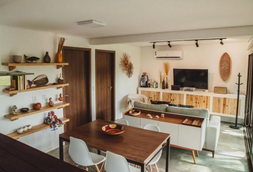 a living room with a table and a tv at Pousada Moana in Fernando de Noronha
