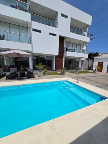 a swimming pool in front of a building at Silver Inn Hotel in Cerro Azul