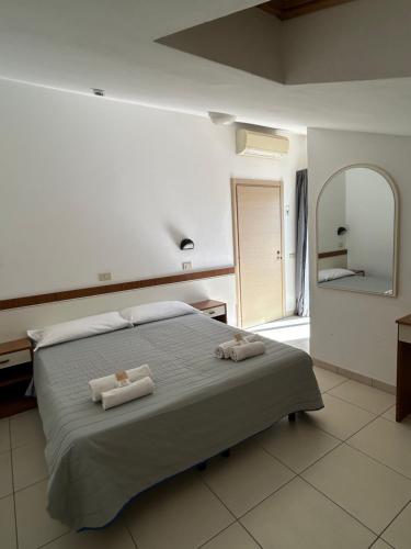 a bedroom with a bed with two towels on it at Hotel Zamagna in Cesenatico