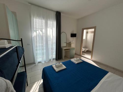 a bedroom with a blue bed with two towels on it at Hotel Zamagna in Cesenatico