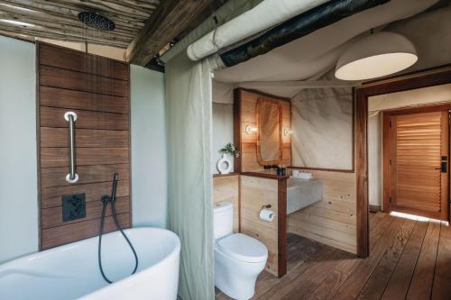 a bathroom with a tub and a toilet and a sink at Lovango Resort and Beach Club in Cruz Bay