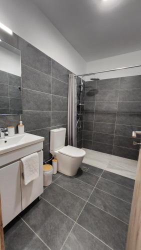 a bathroom with a toilet and a sink and a shower at Boutique Studios & Apartments - by Avelink in Spáta