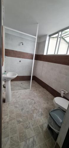 a bathroom with a toilet and a sink at Casa grande en el centro de la cuidad in Medellín