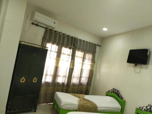 Schlafzimmer mit einem Bett, einem TV und einem Fenster in der Unterkunft Sidi Mehrez HOTEL in Tunis