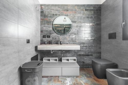 ein Badezimmer mit einem Waschbecken, einem WC und einem Spiegel in der Unterkunft Villetta Mora by BarbarHouse in Torre Lapillo