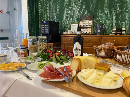 uma mesa com pratos de queijo e carnes e uma garrafa de vinho em Vinhais Hotel em Vinhais