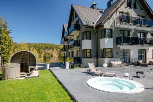 a large house with a hot tub in the yard at Czarny Kamień Resort & SPA in Szklarska Poręba