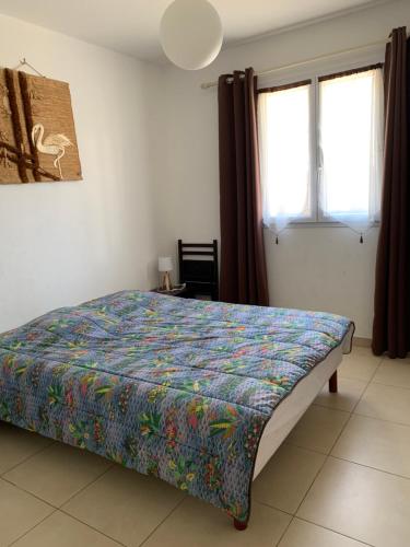une chambre avec un lit avec une couette colorée dans l'établissement 3p, grd terrasse, jardin, centre-ville, 150m de la mer, à Algajola
