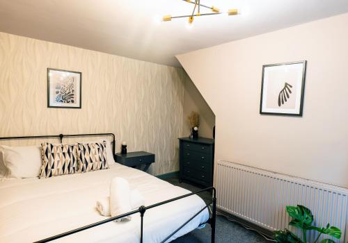 a bedroom with a bed and two pictures on the wall at Park Place - 1 Bedroom Apartment in Bristol by Mint Stays in Bristol