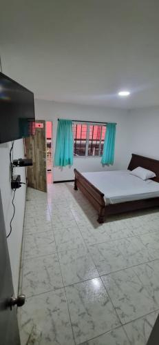 a bedroom with a large bed and a large window at Casa grande en el centro de la cuidad in Medellín