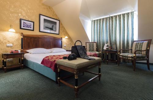 a hotel room with a bed and a chair at Sebnitzer Hof by STEIGER Hotels in Bad Schandau