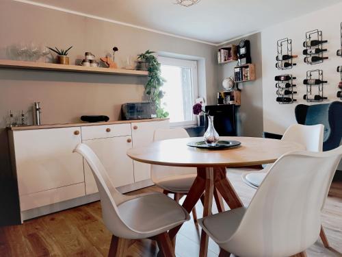 uma cozinha com uma mesa e cadeiras brancas em Bricco Nebbiolo em Neviglie