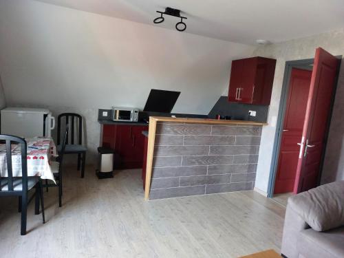 - une petite cuisine avec des placards rouges et un comptoir dans l'établissement bonne nuit, à La Chaussée-Saint-Victor