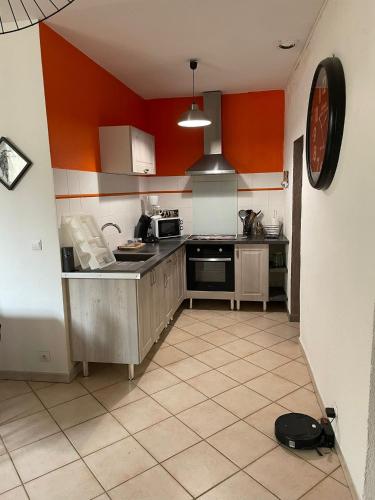 - une cuisine aux murs orange et blancs dans l'établissement Arles appartement en plein centre historique, à Arles