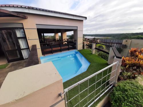 un patio trasero con piscina y una casa en Lagoon Ndziva, Bilene, en Vila Praia Do Bilene