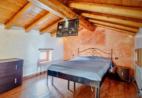 a bedroom with a bed in a room with wooden ceilings at Fienile ristrutturato in Zago