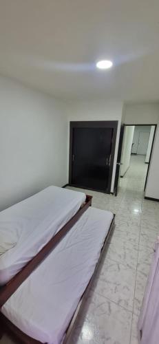 a bedroom with two beds and a flat screen tv at Casa grande en el centro de la cuidad in Medellín