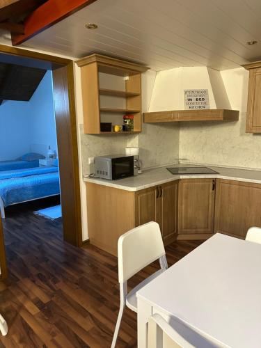 uma cozinha com armários de madeira e uma mesa e cadeiras em Apartma Popeye em Bovec