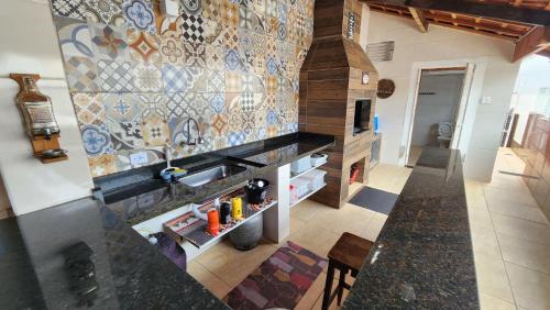 cocina con fregadero y pared de azulejos en NOVO Casa com piscina e Wi Fi em Mongagua SP, en Praia Grande