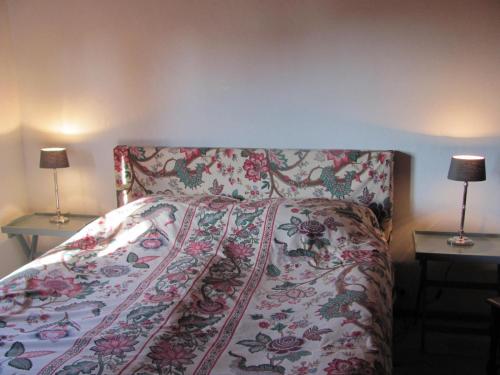 a bed in a bedroom with two lamps on tables at Hochwertiges Ferienhaus im romantischen Franken in Colmberg