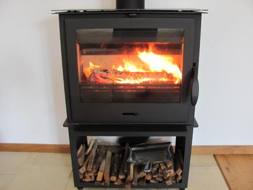 a stove with a fire in a room at Hochwertiges Ferienhaus im romantischen Franken in Colmberg