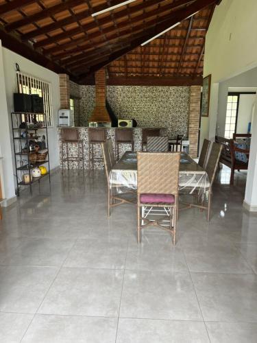 a dining room with chairs and a table and a bar at Lindo Sítio na Serra Andradas a Poços de Caldas in Andradas