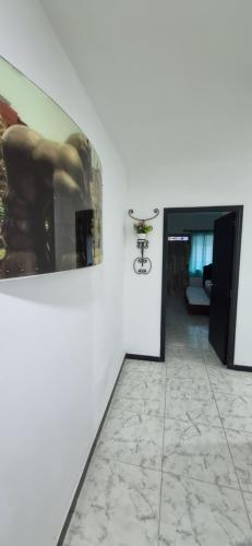 a room with a painting on the wall and a hallway at Casa grande en el centro de la cuidad in Medellín