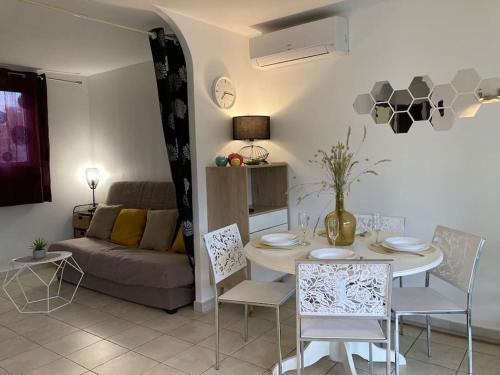 un salon avec une table et un canapé dans l'établissement Maison à 2min à pied du centre de porto vecchio, à Porto-Vecchio